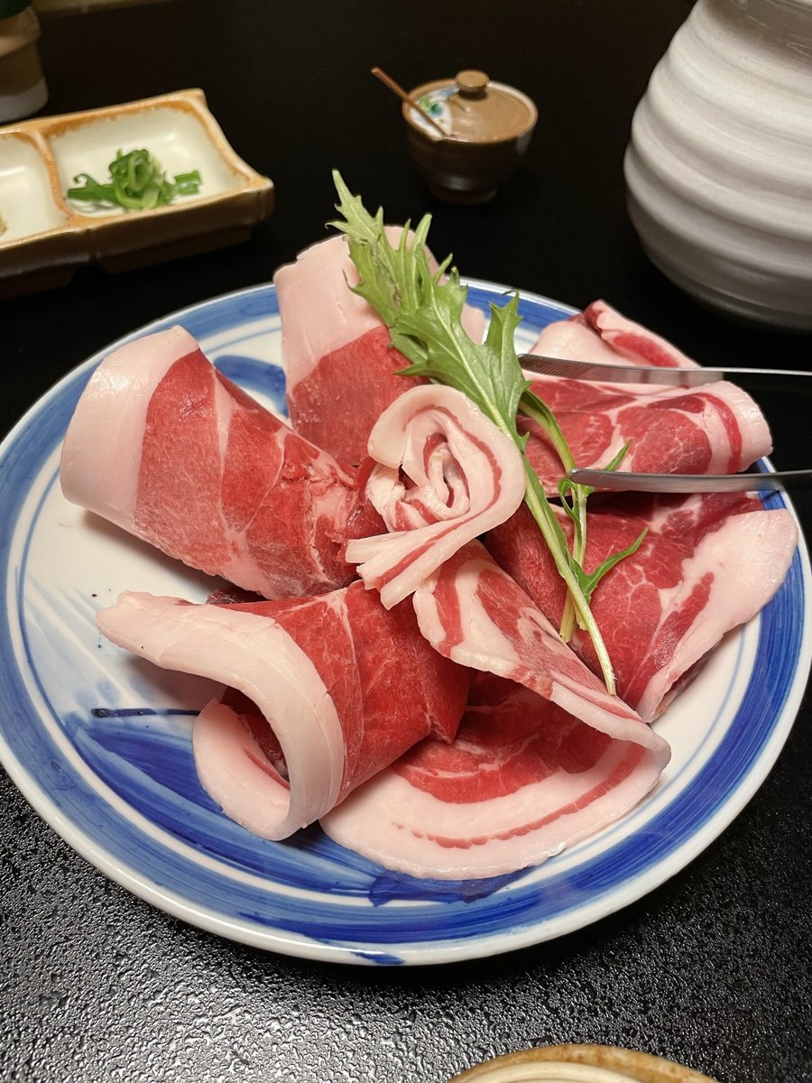 皿に盛られたぼたん鍋用の猪肉。赤身と白い脂が層になっている
